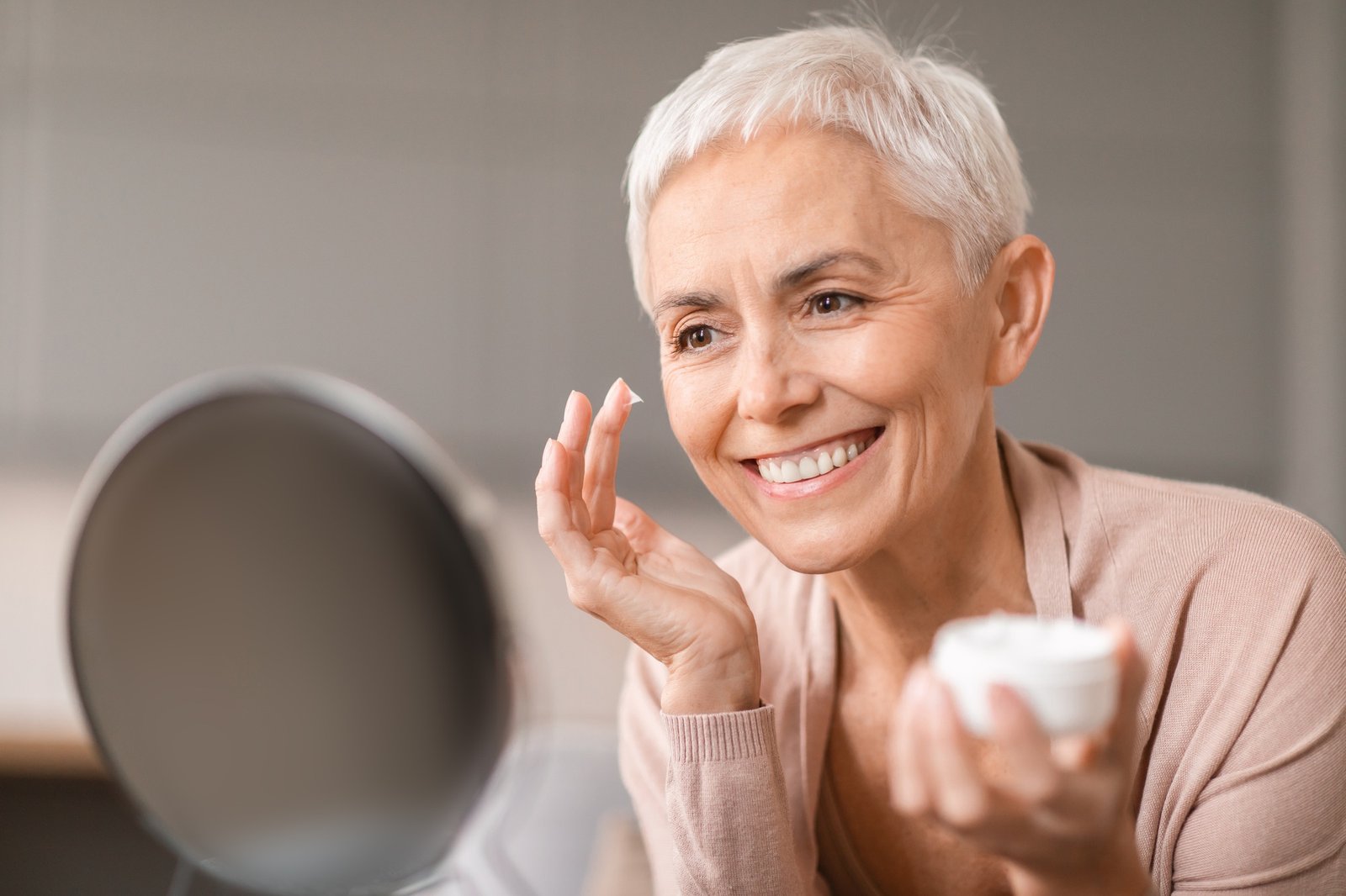 Gorgeous Mature Woman Applying Facial Moisturizer Preventing Wrinkles At Home